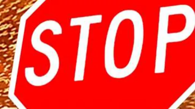 Red STOP sign in front of flying sparks and intense light, symbolizing danger, emergency stop, or arc flash hazard.